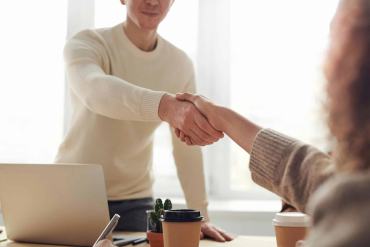 Deux personnes se serrant la main, symbolisant la confiance, l’accord et la relation humaine