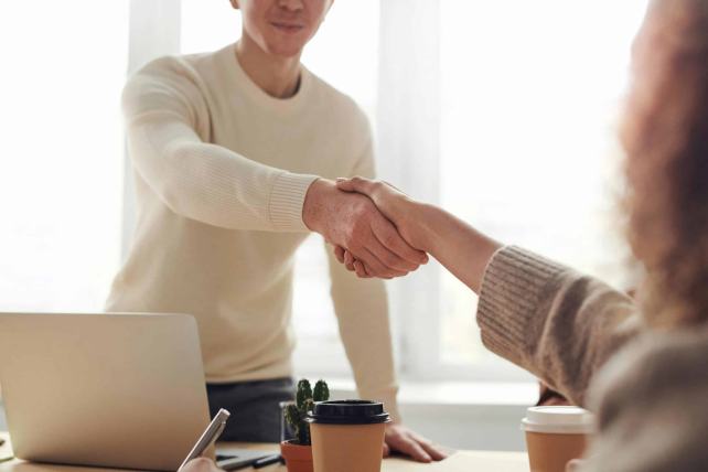 Deux personnes se serrant la main, symbolisant la confiance, l’accord et la relation humaine