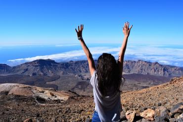 Femme levant les bras symbolisant la confiance en soi, la liberté intérieure et le dépassement des blocages