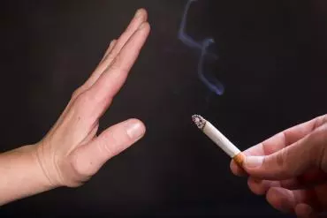 Une main face à une cigarette pour dire non