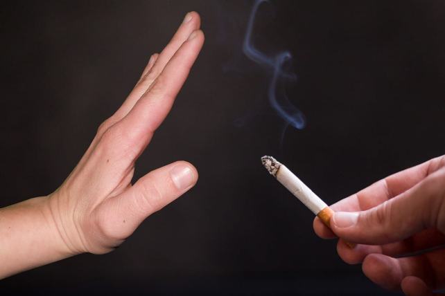 Une main face à une cigarette pour dire non