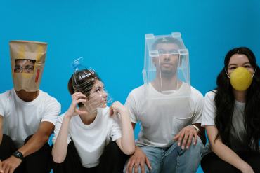 quatre personnes avec le visage recouvert soit d'un masque ou d'un sac