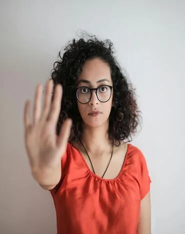 femme montrant sa main en signe de stop à la procrastination femme montrant sa main en signe de stop à la procrastination